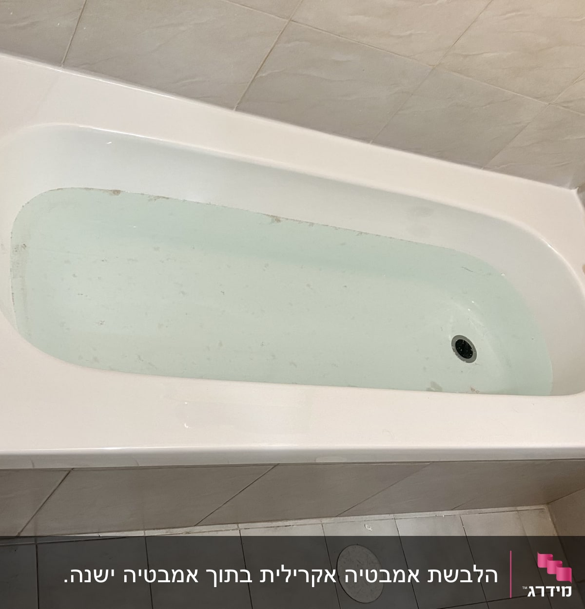 אמבטיה לבנה מלאה במים עם ברז מתכת